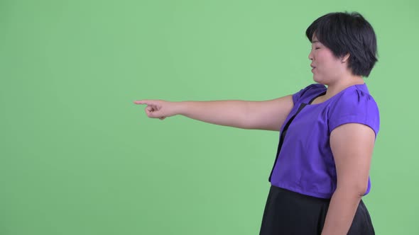 Profile View of Happy Young Overweight Asian Woman Pointing Finger