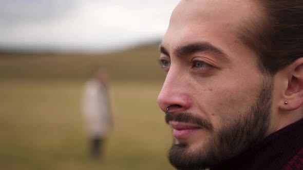 A Porter of a Man in a Field with Blue Eyes a Beard Who Looks Into the Horizon