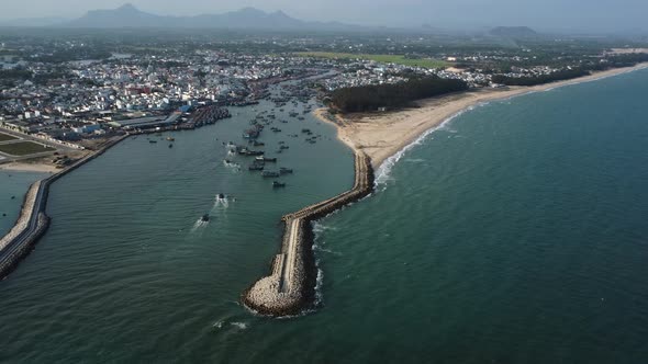 Aerial, breakwater structure protecting fishing harbor in Southeast Asia from rising sea levels