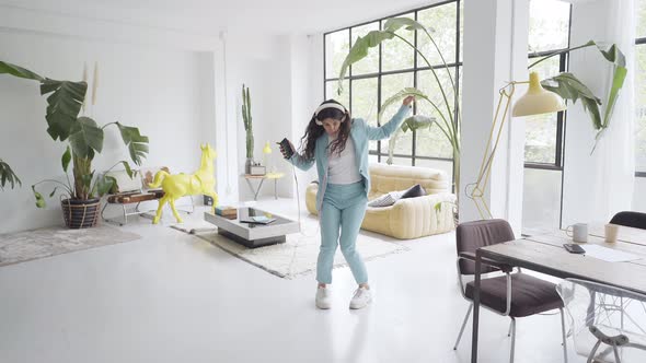 Happy Cheerful Young Attractive Business Woman in Formal Suit Dancing Victory Dance in Home Office