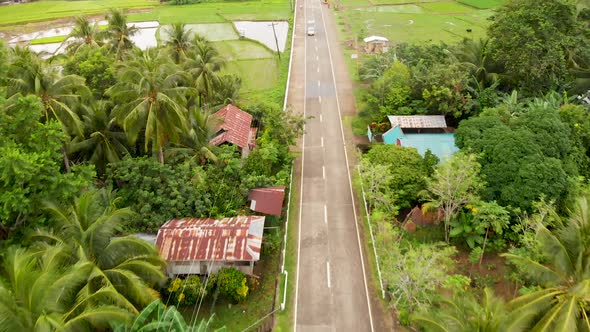 drone aerial of rice fields and road with cars in a small village in the Philippines 4k