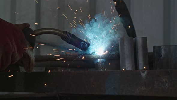 Slow motion of a welder welding construction steel frames
