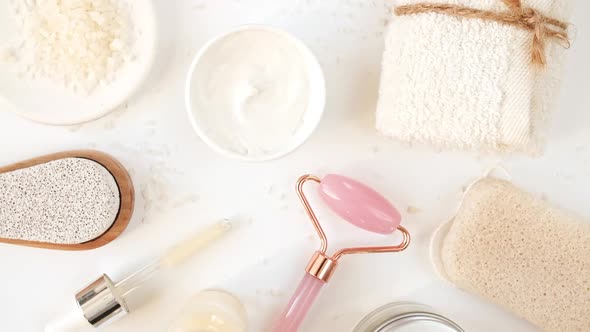 Rotation of Pink Quartz Facial Roller and Glass Bottle with Pipette with Gel Fluid Collagen Serum