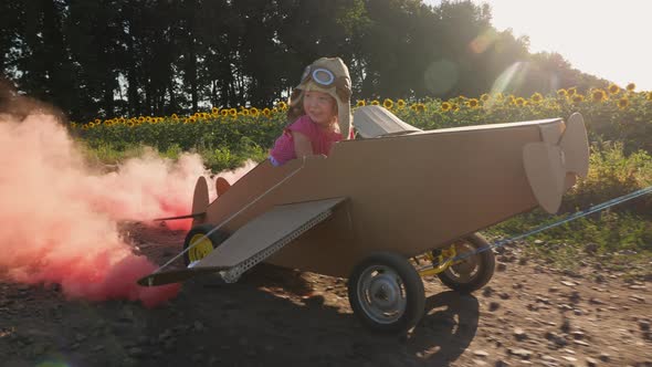 Happy Little Girl Driving a Cardboard Plane