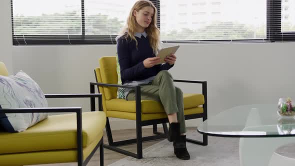 Woman sitting and looking at touch pad