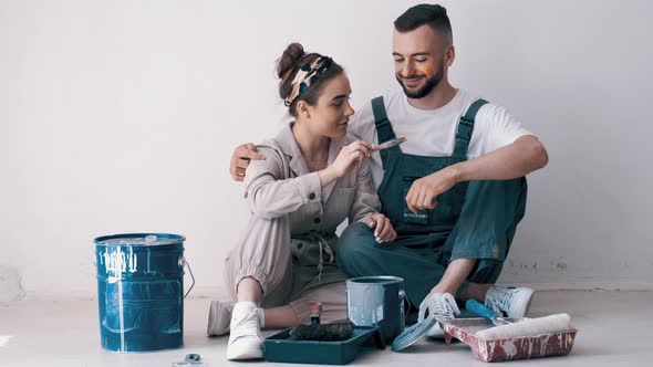 Happy Couple Painting Their First Apartment Together