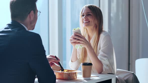Businessman and woman talking and laughing in restaurant