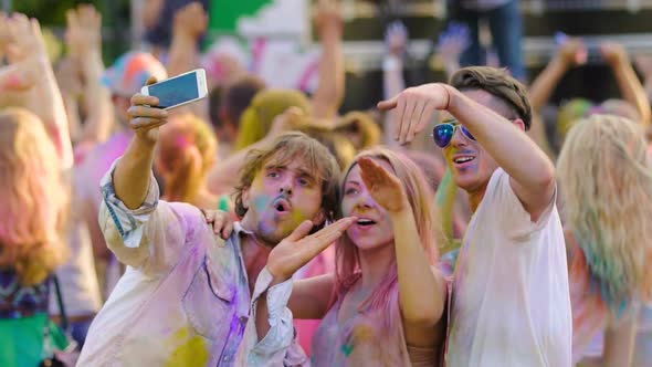 Joyful Friends Waving Hands and Dancing, Posing for Phone Camera at Festival