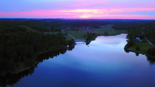 Aerial drone view over a lake and towards the countryside, a purple sky, at a colorful sunset or dus