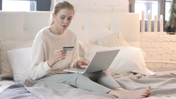 Successful Online Shopping by Woman Sitting in Bed