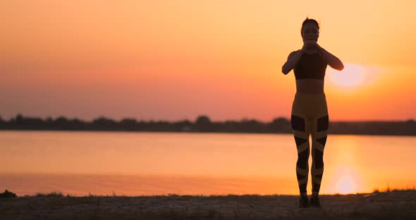 Side View of Young Woman Doing Squats Outdoors