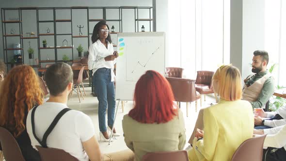 Young Successful Female Entrepreneur of African Descent Giving a Speech To Corporate Employees