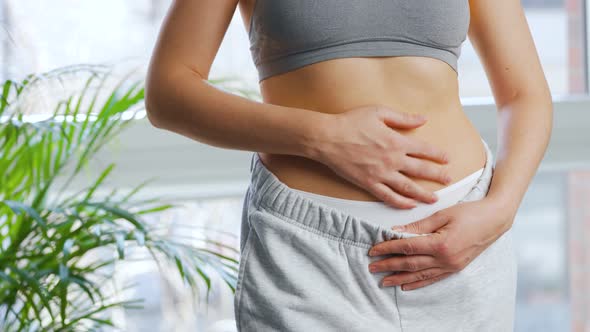 Woman Puts on Her Pants Strokes Her Stomach and Gives a Thumbs Up