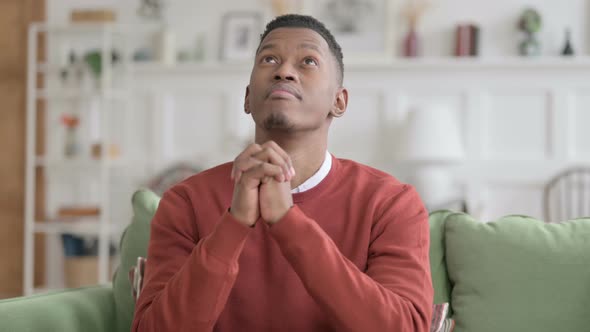 Portrait of African Man Praying with Fingers Crossed