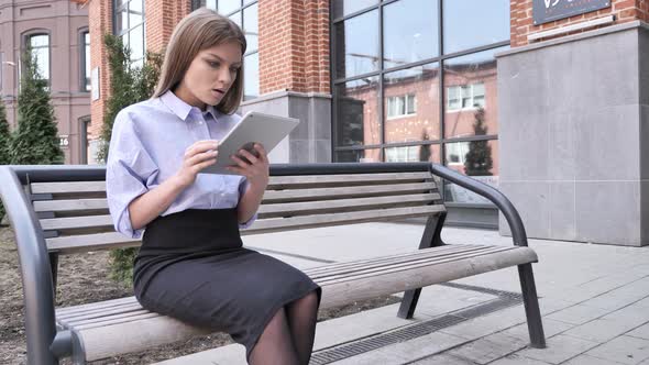 Woman in Shock while Using Tablet Outside Office Building