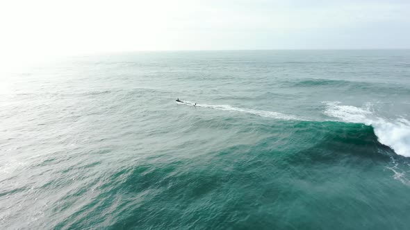 Sportsman Surfs Ocean Wave with Heavy Foam Following Scooter