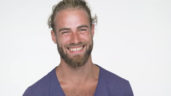 Closeup Portrait of American Handsome Guy Wearing Blue Tshirt Looking at Camera Smiling Broadly