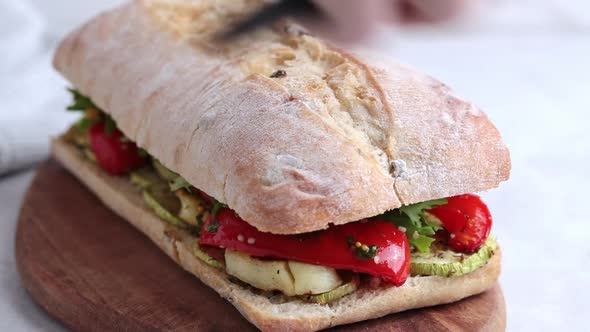 Making sandwich with grilled vegetables, cheese and ciabatta.