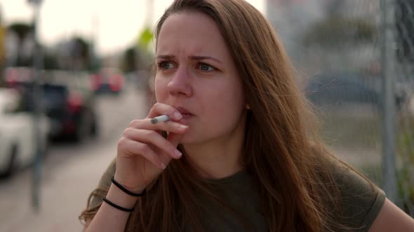 Young Woman Lost in Thought Smokes a Cigarette