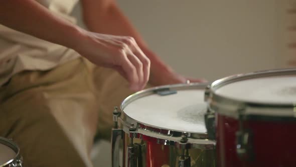 Drummer preparing and tuning snare drum before practice begins.