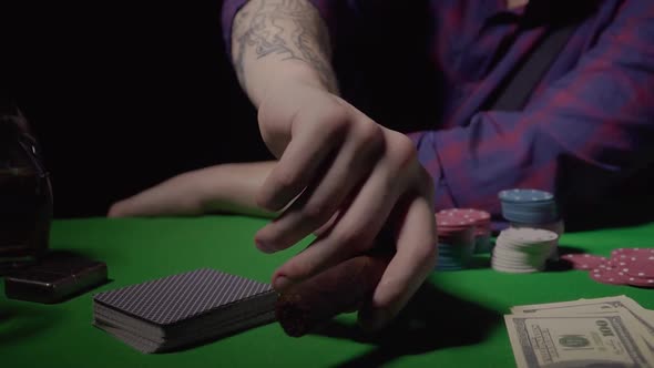 A Guy Takes a Cigar From a Green Table in a Casino