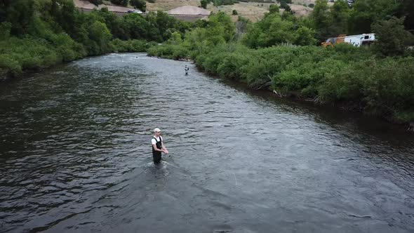 Drone Shot rotating around a man Fly Fishing in the Provo River in the Mountains of Utah.