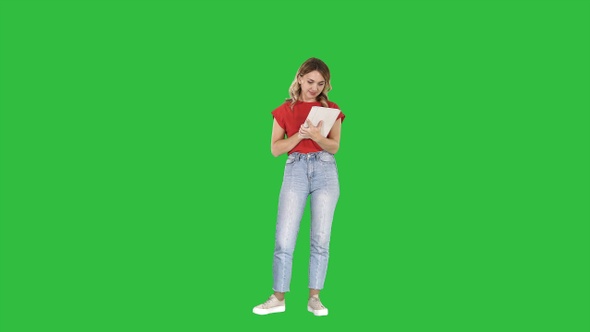 Beautiful modern woman using digital tablet on a Green