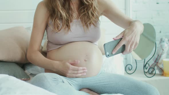 Closeup Pregnant Woman Taking Photo of Belly. Belly Mother Showing Thumb Up