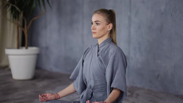 Elegant Woman in Stylish Robe Sitting in Lotus Pose