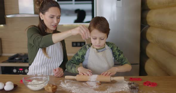 Happy Mother and Son Cooking Cookies Together in the Kitchen