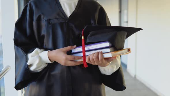 Indian Female Graduate in Mantle Stands with a Books in Her Hands