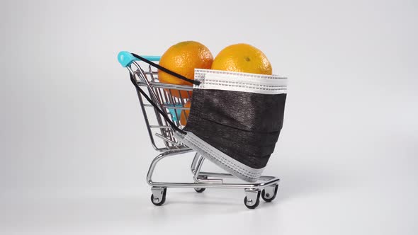 Shopping cart full of tangerines with a medical protective mask 