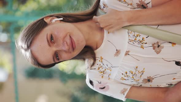 Portrait of Charming Young Girl with Brown Hair and Blue Eyes and Freckles Having Earphones Wearing