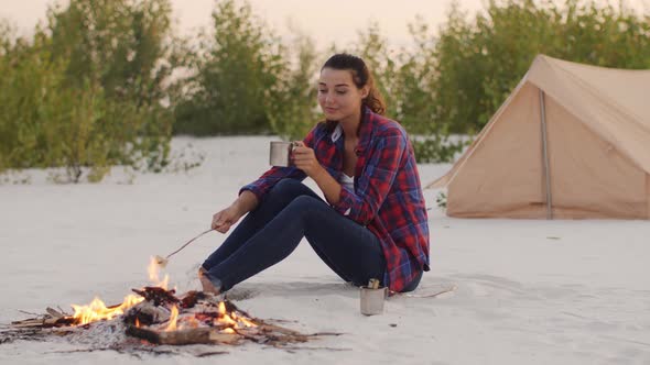 Tourist Woman Camping Near Campfire Outdoors on the Nature