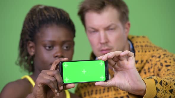 Young Multi-ethnic Couple Showing Phone Together