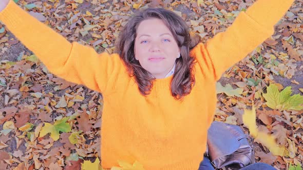 Happy Smiling and Playing Woman with Autumn Leaves