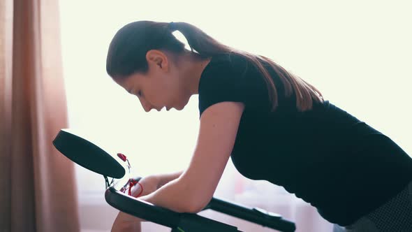 Tired Woman Leans on Modern Treadmill After Training in Room