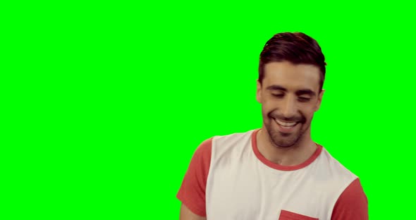 Smiling man standing against green screen