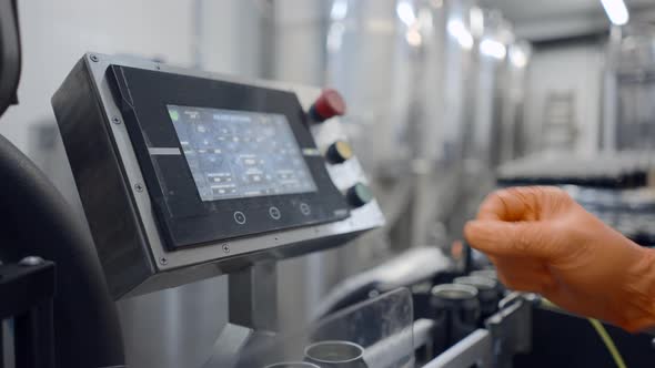 Worker's Hand In Rubber Glove Pressing On Automated Machine In A Beer Factory