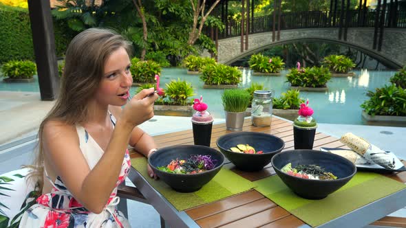 Young Woman in Modern Trendy Outdoor Cafe Drinking Healthy Vegan Juice