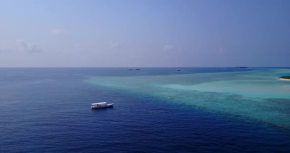 Wide fly over travel shot of a white sandy paradise beach and aqua turquoise water background in bes