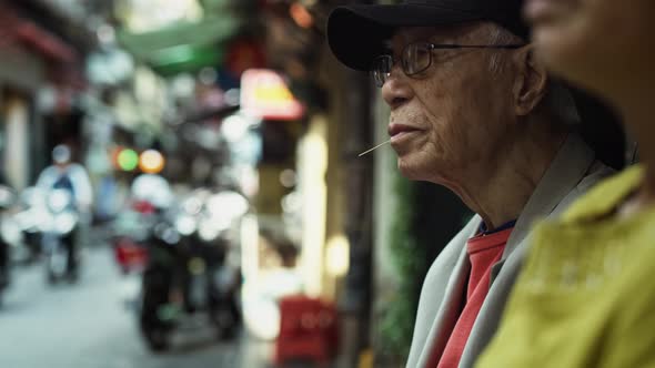 Handheld view of Vietnamese senior man in the street. Shot with RED helium camera in 8K