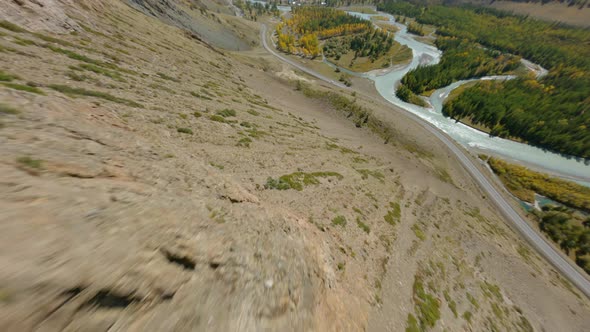 Aerial View Speed Dive From Mountain Peak Texture Dry Grass River and Highway Road Sunny Panorama