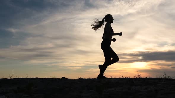 Young Lady Running on Seashore at Sunset