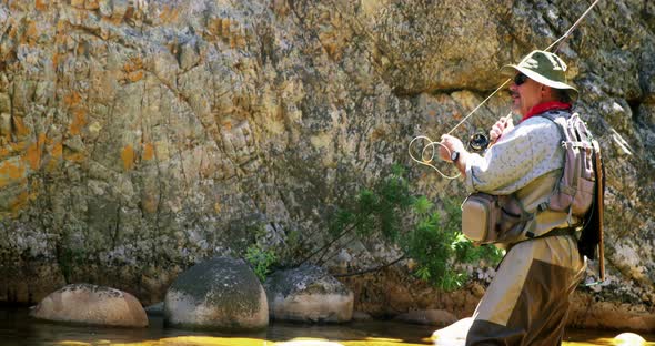 Fisherman fly fishing in river