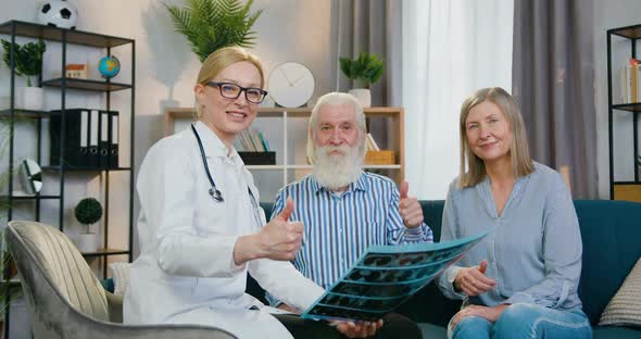Doctor which Holding X-ray Scan and Looking at Camera with Attractive Satisfied Mature couple