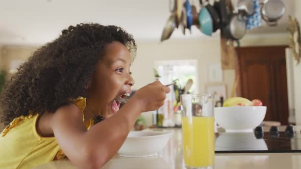 Side view of African american girl eating cereals