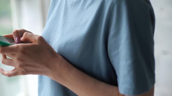 Close Up of Hands of Unrecognizable Woman Using Cell Phone Near Window