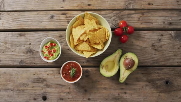 Video of tortilla chips, guacamole and salsa dip on a wooden surface