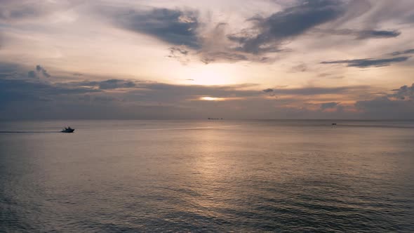 Drone footage of speedboat sailing from left to right during beautiful sunset, Thailand.